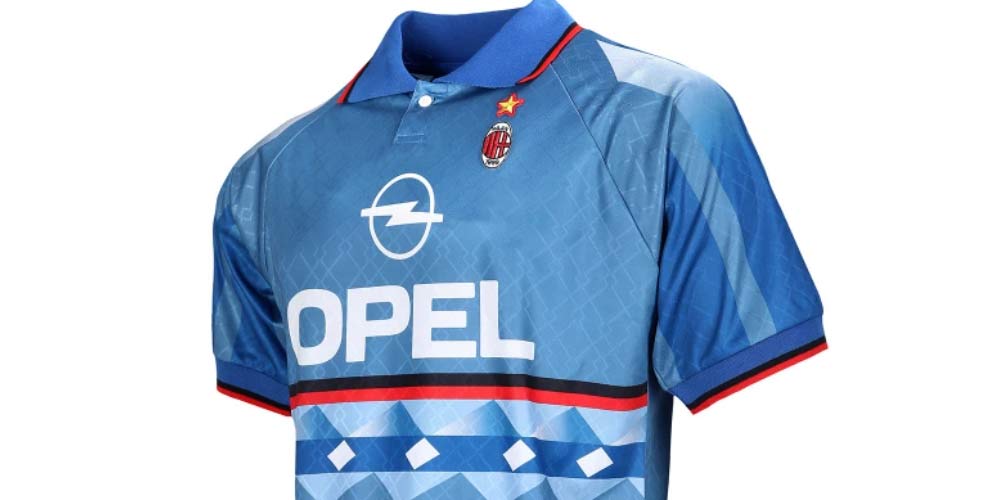 Camisola azul para a época 1995/96.  O kit está disponível nas lojas do AC Milan e no modo FUT do FIFA 22